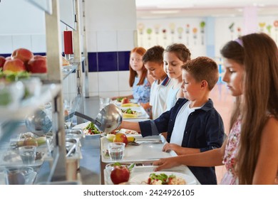 Smiling male and female students taking food while standing in line during lunch break in school cafeteria - Powered by Shutterstock