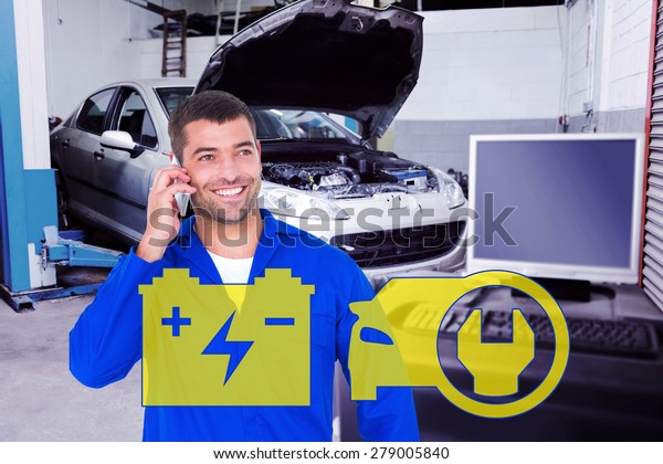 Smiling\
male mechanic using mobile phone against\
workshop