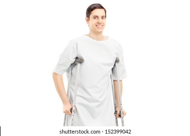 Smiling Male Patient In Hospital Gown With Crutches Isolated On White Background