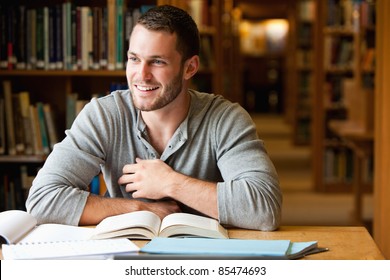 Smiling Male Student Working In A Library