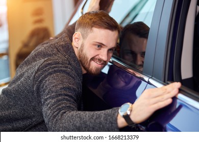 Smiling Man Adores His New Modern Luxury Car. Love At First Sight, Guy Checking The Polish Of The Car After Mending It. Close Up Photo. You Are My Baby