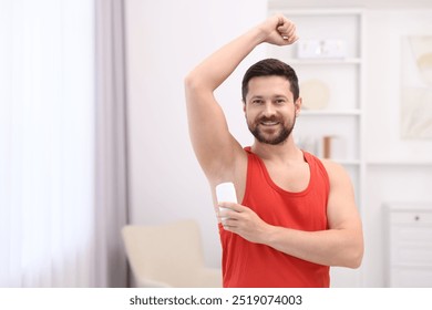 Smiling man applying solid deodorant at home. Space for text - Powered by Shutterstock