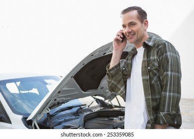 Smiling Man Calling For Assistance After Breaking Down In A Car Park