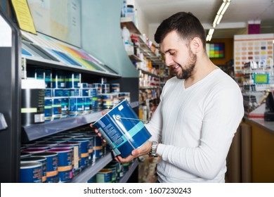 Smiling Man Choosing New Wall Paint In Paint Supplies Store