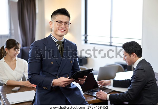 A smiling man at an English conversation meeting\
between Asians and Latins