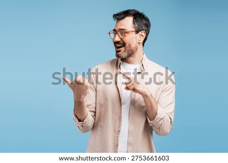 Smiling man with glasses gesturing to empty space, presenting a concept or product