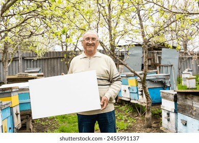 Smiling man holding a canva in garden - Powered by Shutterstock