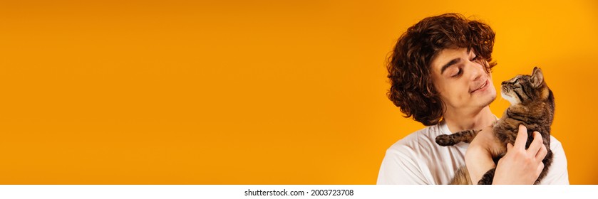 Smiling Man Holding Cat Isolated On Orange, Banner