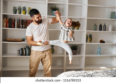 Smiling Man Holding Her Little Sister's Arm And Leg Shaking Her, Close Up Photo.