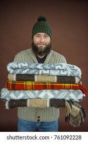 Smiling Man Holding Pile Of Blankets