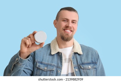 Smiling Man Holding Wireless Portable Speaker On Blue Background