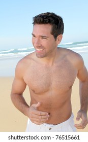 Smiling Man Jogging On A Sandy Beach