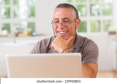 Smiling Man At Laptop In Kitchen