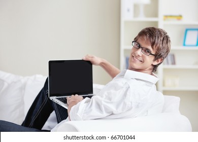 A Smiling Man With A Laptop Looks Back