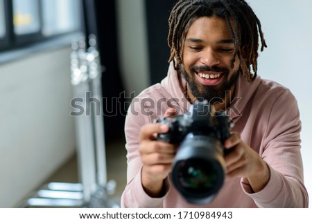 Smiling man looking at camera. Black man in photography studio.