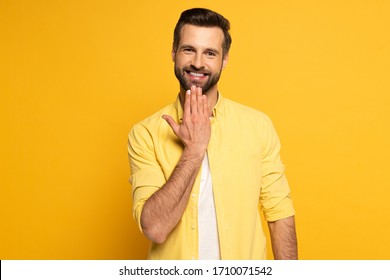 Smiling Man Looking At Camera While Showing Word Speak In Sign Language On Yellow Background