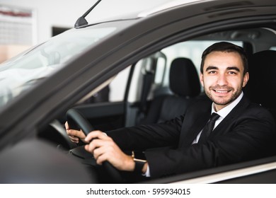 Smiling man looking from a car window