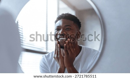 Smiling Man Looking at His Reflection in a Round Mirror in a Bright Room