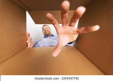 Smiling Man Looking Inside The Box And Reaching For Goods