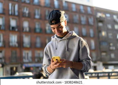 Smiling Man Looking At The Phone In The Street In Winter