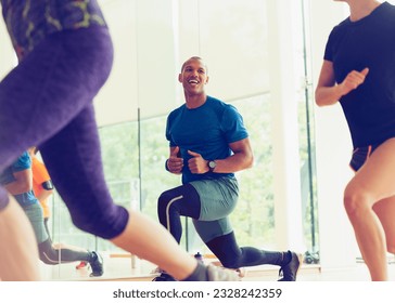 Smiling man lunging in exercise class