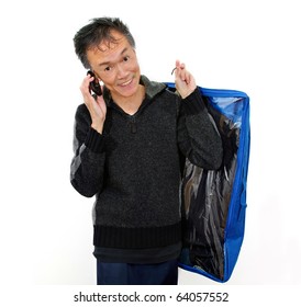 Smiling Man On Cell Phone Carrying Clothing  In  Dry Cleaning Plastic Bag. White Studio Background