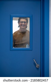 A smiling man opening the door and looking happy