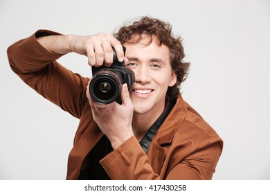 Smiling man photographing isolated on a white background - Powered by Shutterstock