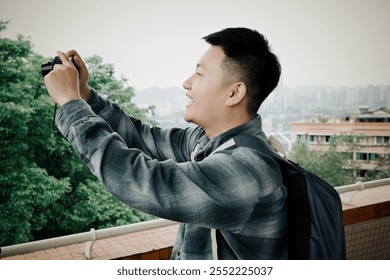 Smiling man, plaid shirt, holding camera, capturing photo, urban background. - Powered by Shutterstock