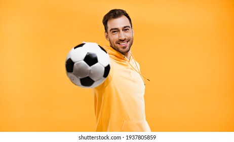 Smiling Man Playing With Football Isolated On Yellow