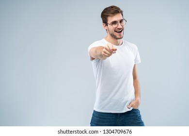 Smiling man pointing his finger to you over gray background