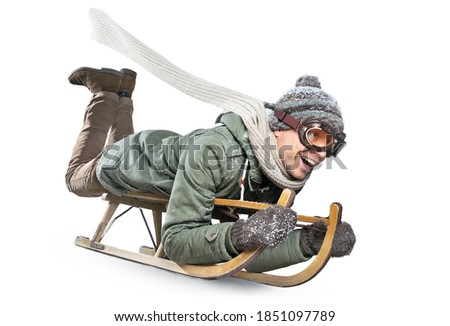 Smiling man riding a sled - isolated on white