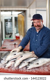 Smiling Man Selling Salmon At Fish Market