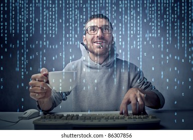 Smiling Man Sitting In Front Of A Computer Screen And Holding A Cup Of Coffee