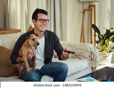 Smiling Man Sitting With His Dog Watching The Television At Home