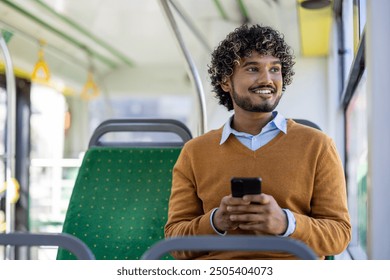 Smiling man sitting on bus seat using smartphone during commute. Relaxed expression capturing moment of joy and connectivity. Concept of travel, technology, public transportation. - Powered by Shutterstock