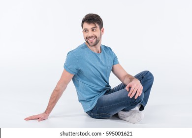 smiling man sitting on floor isolated on white