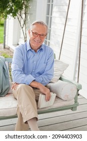 Smiling Man Sitting On Porch Swing