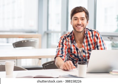 Smiling Man Sitting At The Table 