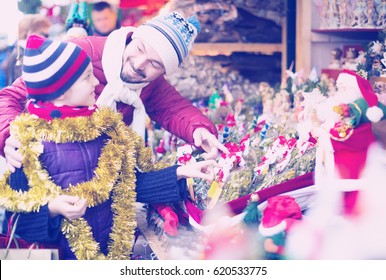 Smiling man with small daughter in Christmas market - Shutterstock ID 620533775