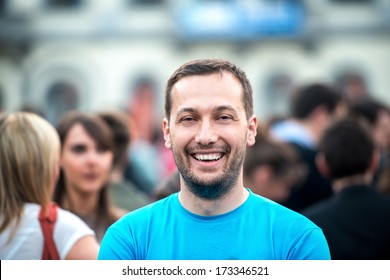 Smiling Man Standing On A Crowded Street