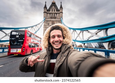 Smiling man taking selfie picture in London, England - Young tourist male taking memory pic with iconic england landmark - Weekend holidays concept - Powered by Shutterstock