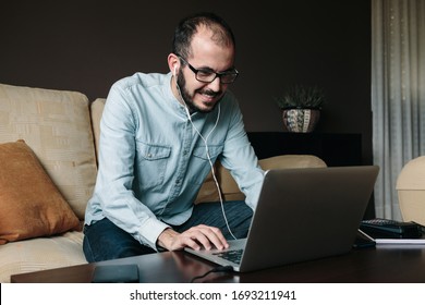 Smiling Man Videoconferencing With Co-workers While Working Remotely From Home