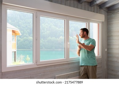 Smiling Man Waving Hello Through The Window Of His Apartment While Is Having A Coffee.