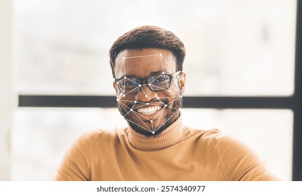 A smiling man wearing glasses sits comfortably in a well-lit indoor space. Graphic overlays illustrate facial recognition technology, highlighting features for identification.