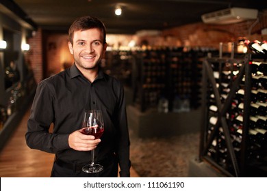 Smiling man in the wine cellar - Powered by Shutterstock