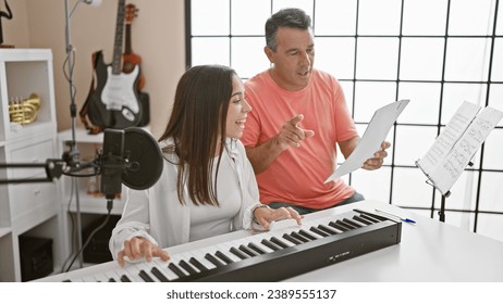 Smiling man and woman musicians engrossed in their music studio lesson, harmonizing melodies on acoustic piano while singing together - Powered by Shutterstock