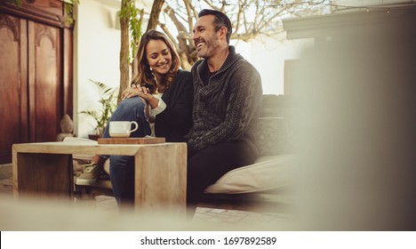 Smiling man and woman sitting at coffee shop. Couple sitting at a cafe during a first date.