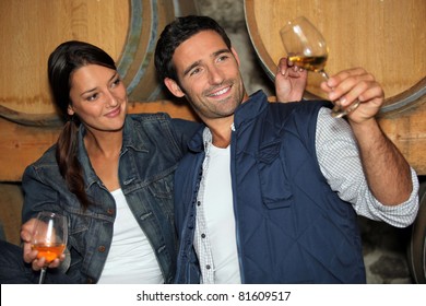 Smiling Man And Woman Tasting Wine In A Cellar