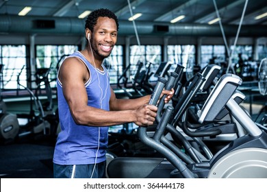 Smiling Man Working Out With Headphones On At The Gym